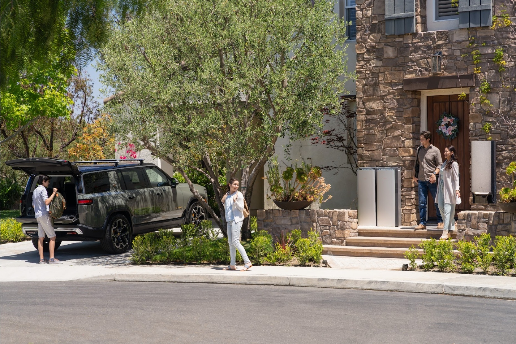 Family leaving home with an electric SUV parked near outdoor energy storage batteries.