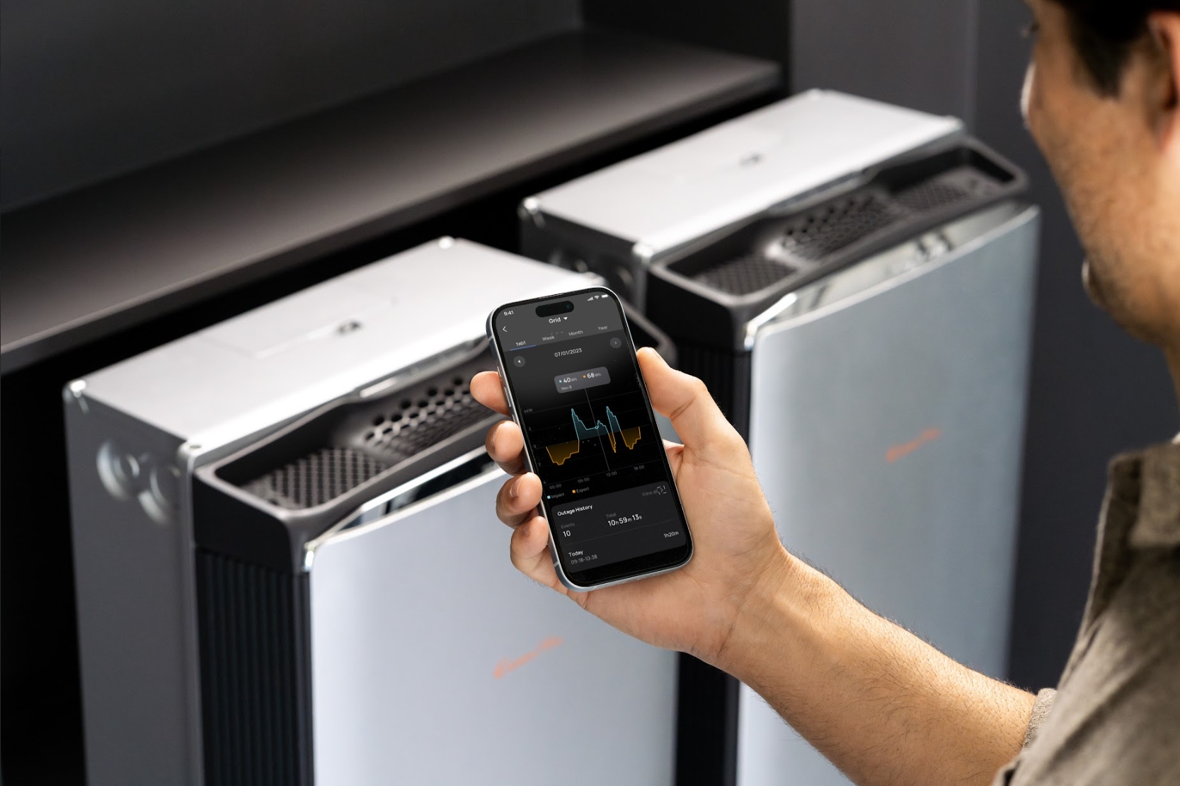 Person monitoring EcoFlow home battery data via a smartphone app.