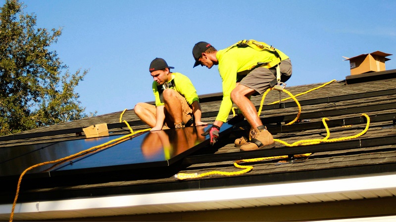 Professionals installing solar arrays